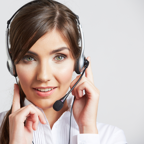 Female employee in a white button-front shirt with a headset on