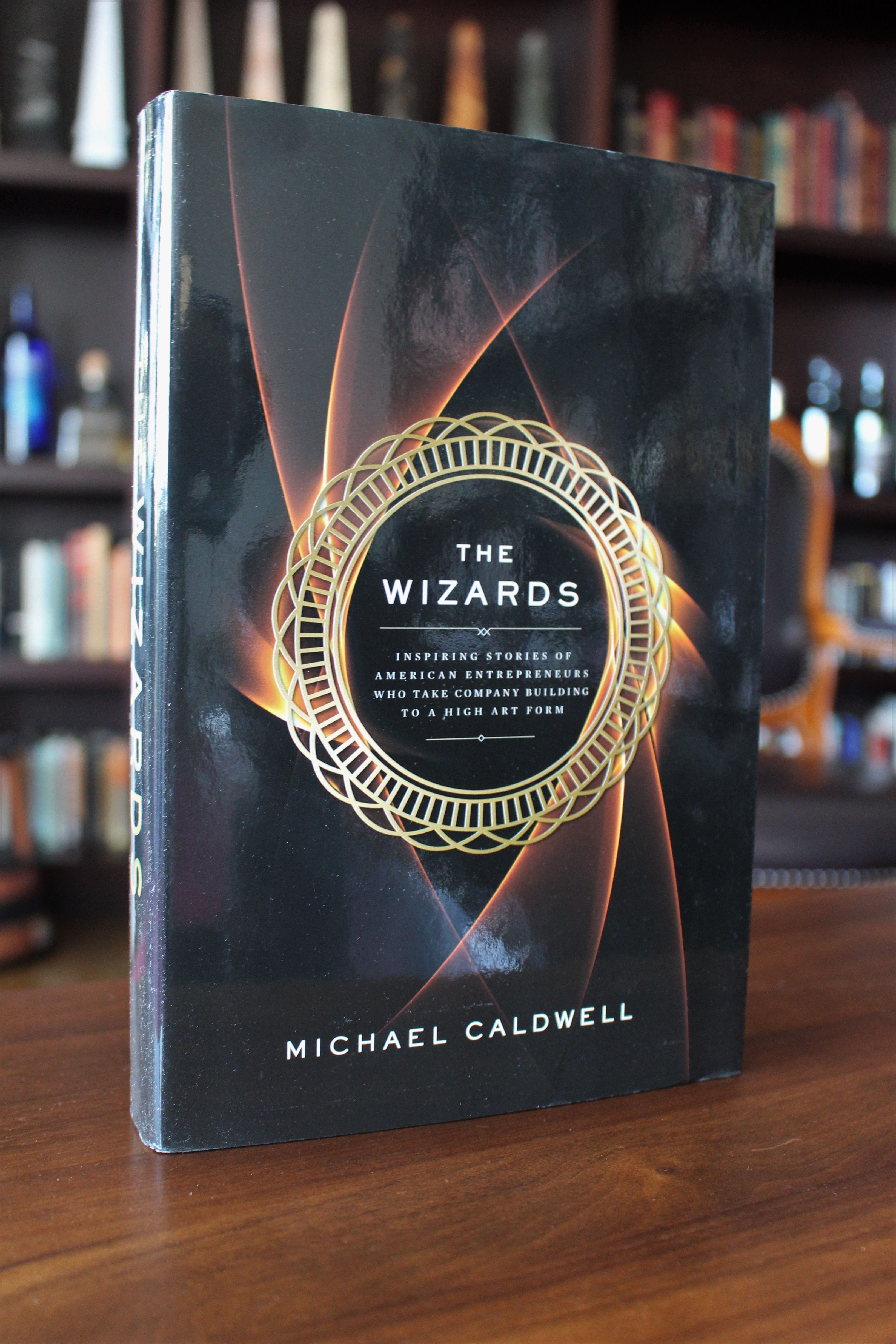 Book cover of The Wizards by Michael Caldwell on a table in our office Whiskey Library