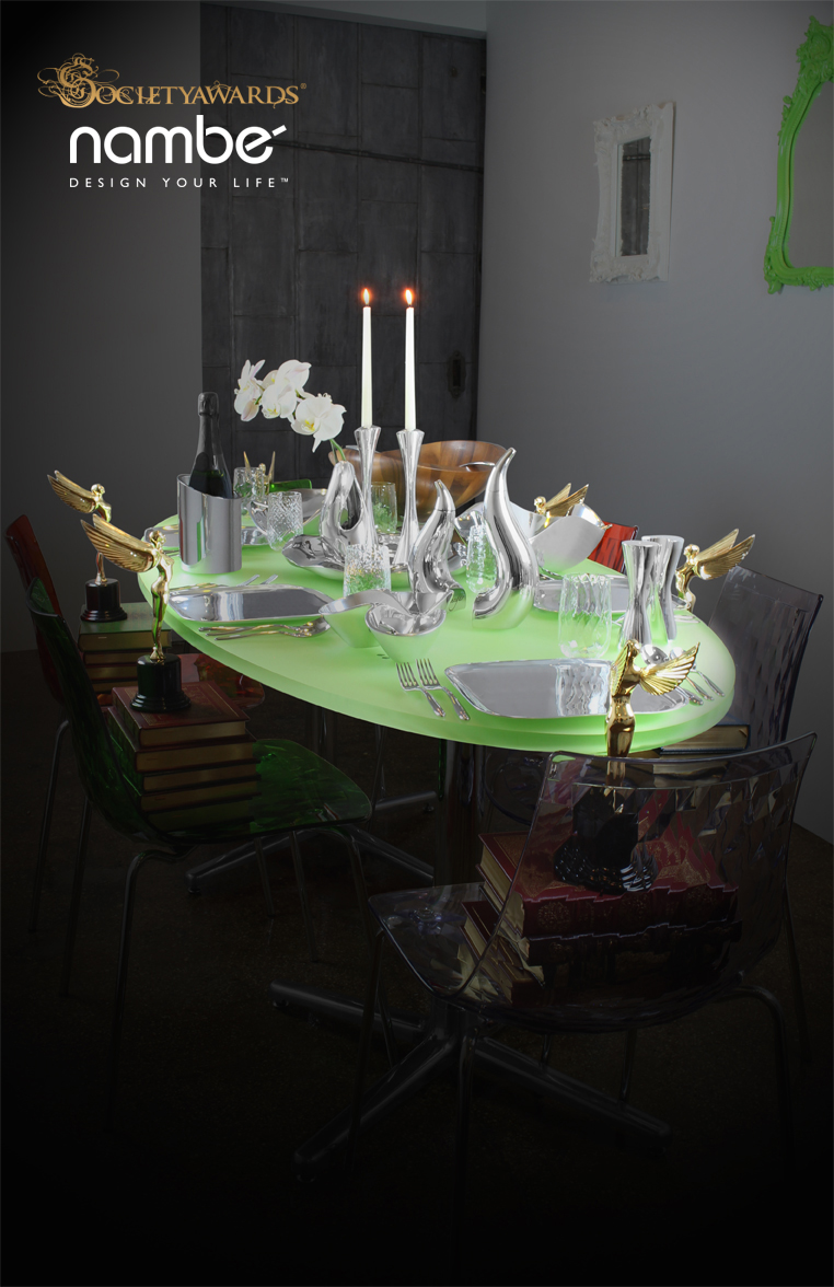 Green dining table set with pieces from the Nambé collection of luxury tableware goods. At each seat around the table is a Society Angel award