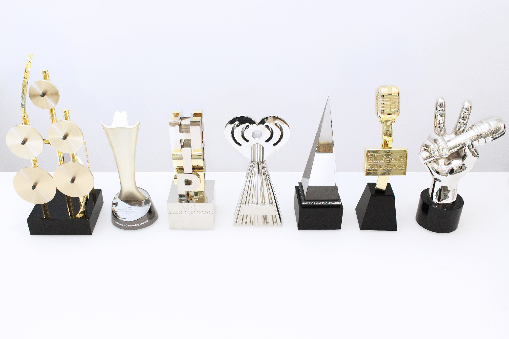 Front view of seven famous custom music awards program trophies, all crafted by Society Awards