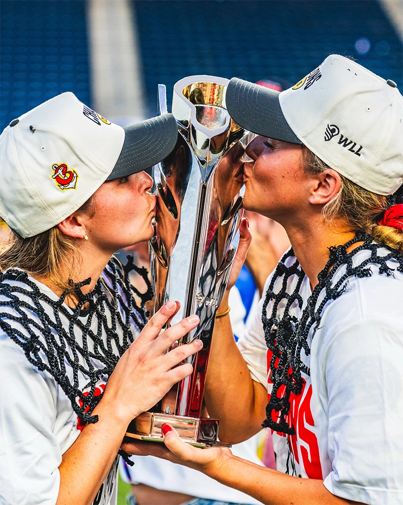 Winners kissing the new WLL 2026 championship trophy