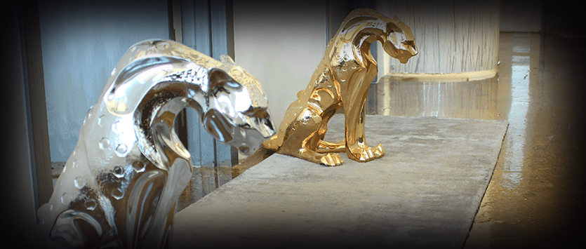 Metallic Silver and Gold Jaguar Statues in Modern Space