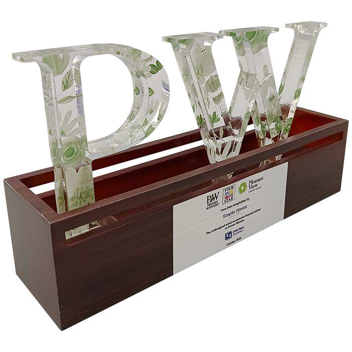 Clear acrylic P W letters with green plant etchings standing in a rectangular wooden box for Proven Winners Pleasant View and Staple Street. Financial Tombstones by Society Awards Finance Group