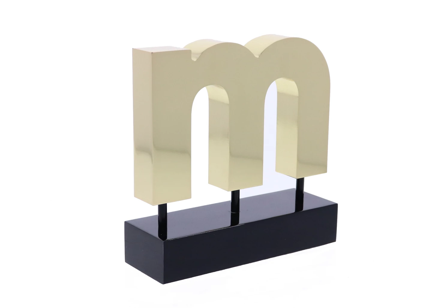 Shiny gold "M" above a black rectangular base