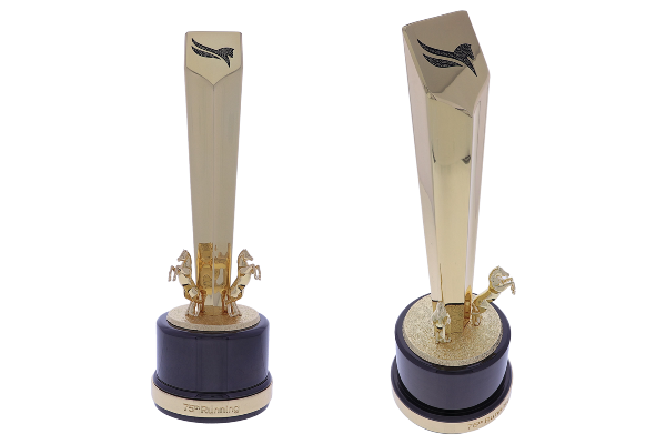 Gold pentagonal tower atop a cylindrical black base with two rearing horses and a logo embellished with black crystals