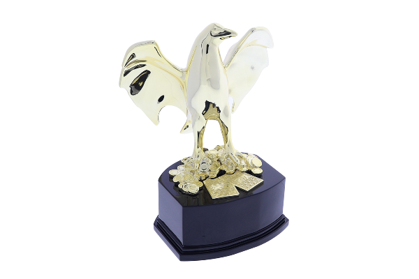 Gold eagle with wings spread standing on chips and playing cards