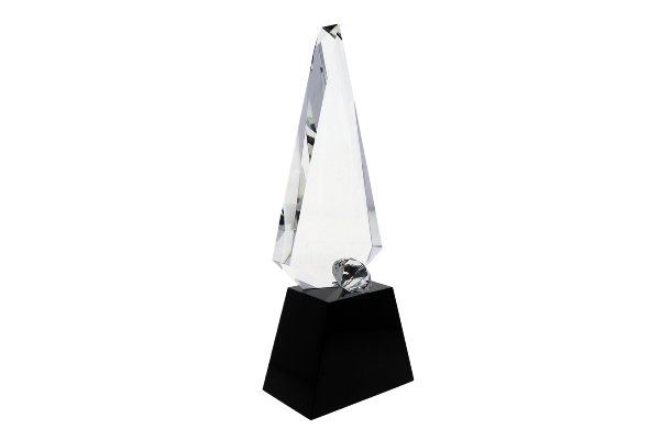 Faceted diamond in front of a crystal sculpture atop a black base