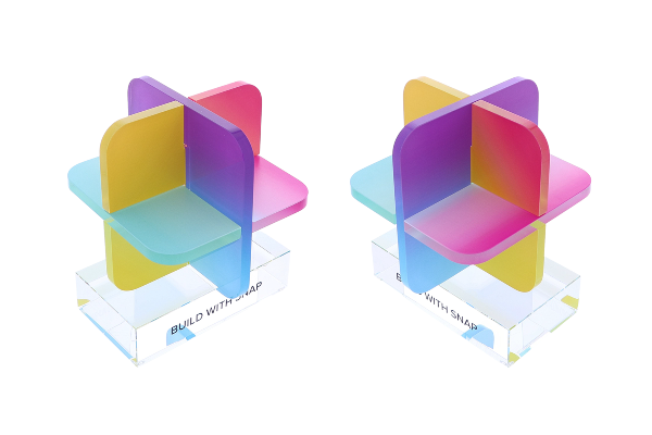 A vibrant, geometric award featuring intersecting translucent panels in a spectrum of colors, elevated on a clear base