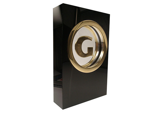 Trophy with golden letter G suspended inside center of a black crystal block.