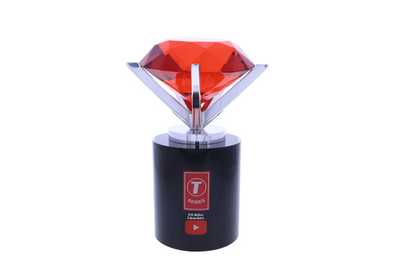 A large red crystal shape, clasped by silver supports, atop a black metal base