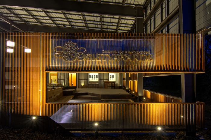 Lighted Society Awards logo at night on front of Grove, OK Production Facility