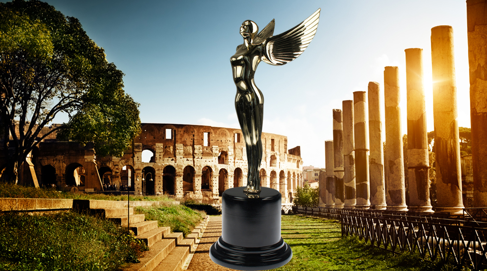 The Society Angel trophy in 24k Gold plating on a round painted wood base with ancient Roman ruins in the background