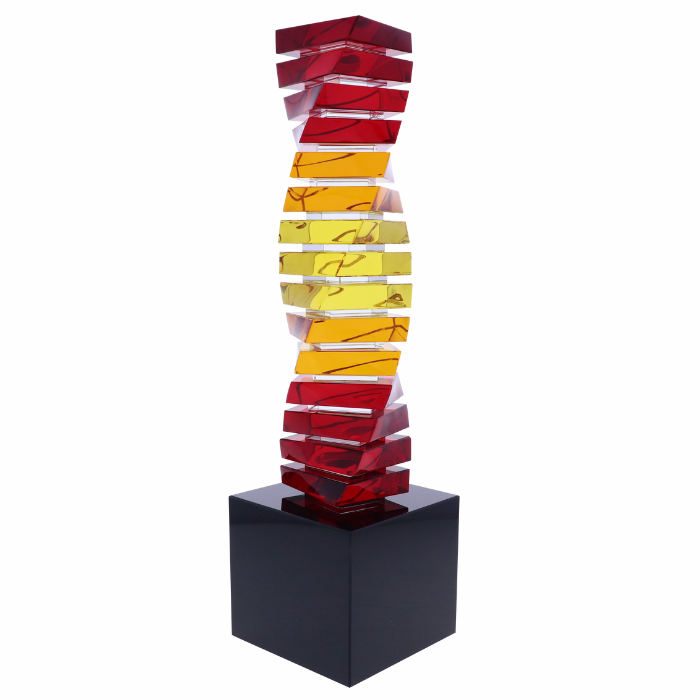 Century Twist crystal award with hues of red, yellow, and orange on a black crystal base
