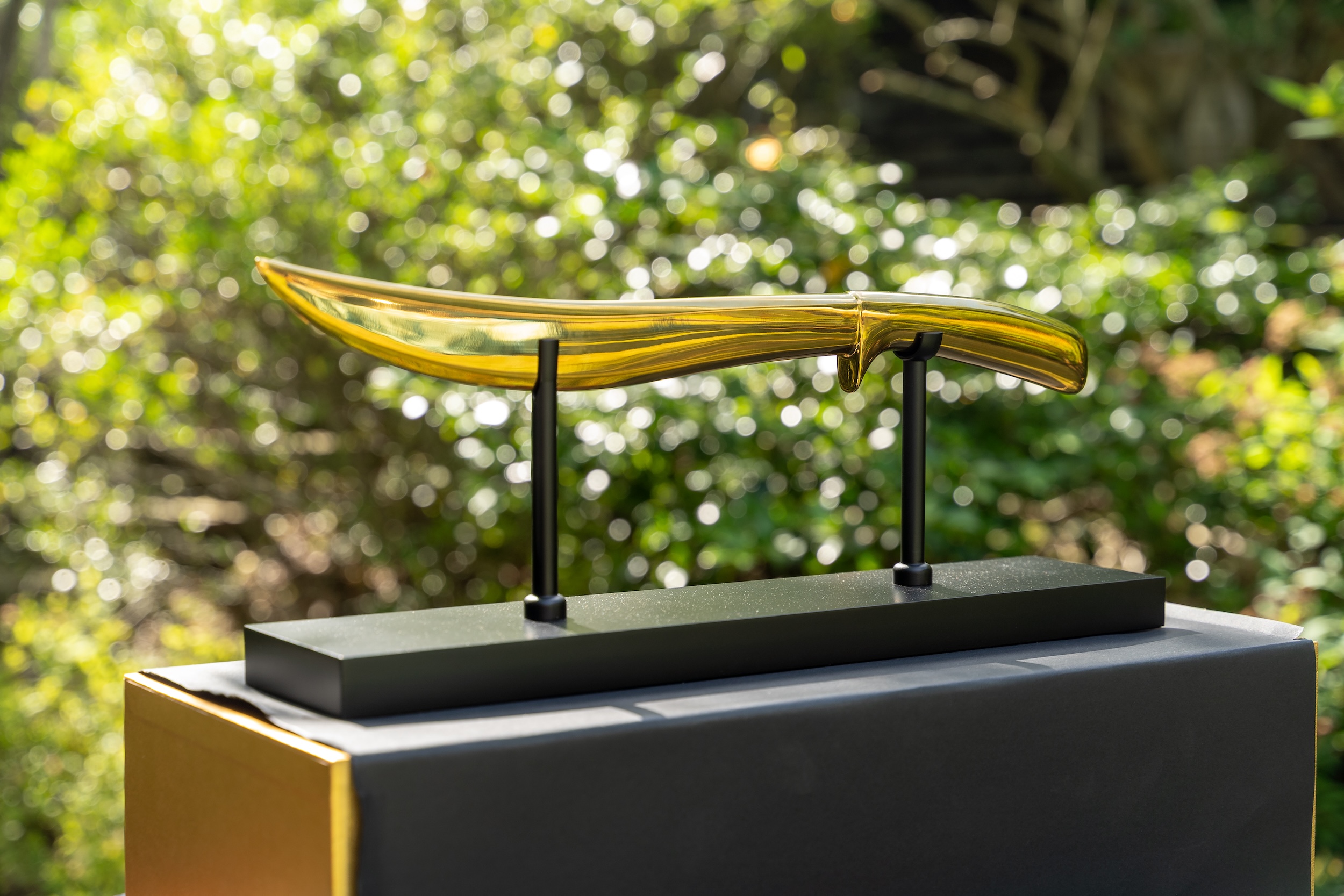 Champagne Saber Displayed Beautifully on a Stand in a Nature Setting