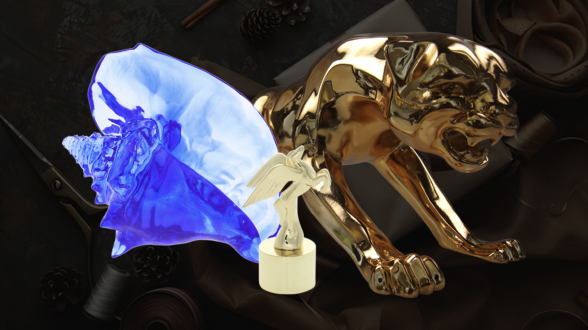 3 unique luxury gifts side by side. Blue crystal conch shell award, miniature gold art deco Pegasus, and gold jaguar statue all created by society awards