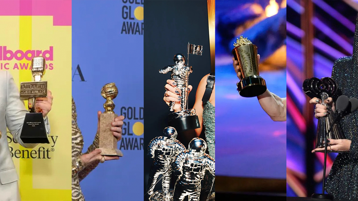 A collage of the billboard music award golden microphone, the golden globes trophy, the MTV video music award moon person trophy, MTV movie award golden popcorn trophy, and the iHeartRadio Awards trophy