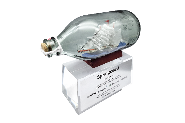 Ship in a bottle deal gift on a base with deal text on a steel plate on a crystal base