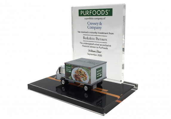 This custom luxury tombstone includes a 3D-printed truck and color printing. It was crafted to recognize a minority investment deal.