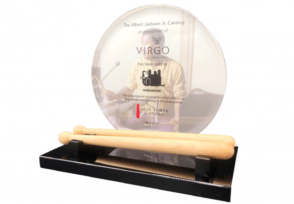 Model baseball bats are displayed on a black base in front of a full color printed crystal circle with details of a financial transaction in this custom deal toy.