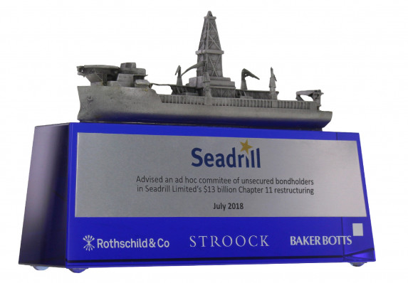 Model ship with fine detail is presented on a tapered blue crystal base for a chapter 11 restructuring deal toy. Includes color printed plate and etched logos.