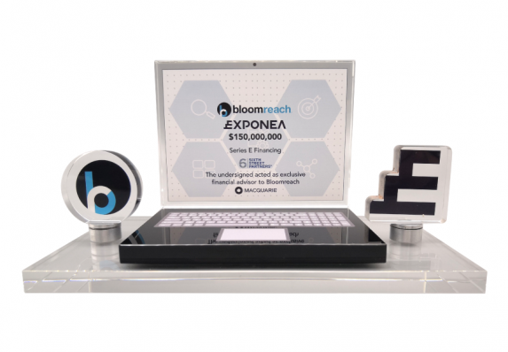 This complex deal gift combines brand logos on metal plaques with financial transaction details on a model laptop computer screen. These elements are combined on a metal base.