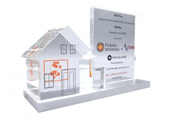 Color printed deal toy with tombstone plaque and crystal model house on a brushed aluminum base. Presented to recognize an acquisition deal.
