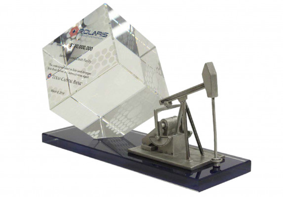 Crystal standing cube printed with tombstone text is mounted on a long black base which includes a silver model oil drill
