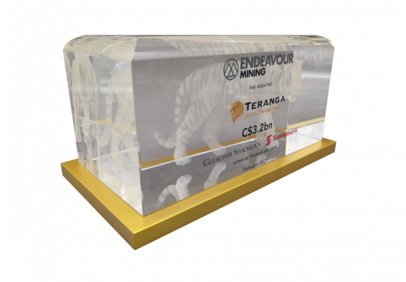 A luxury crystal deal toy for an acquisition featuring 3D etching, color printing atop a gold plated base.