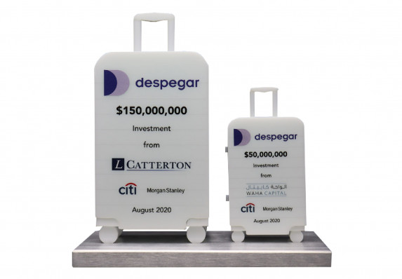 Dual-plaque deal gift with large financial investment transaction outlined on model acrylic luggage.