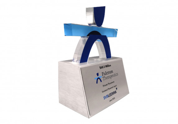 An exclusive deal gift with a large, custom-cut logo presented on a tapered base with tombstone text and transaction details.