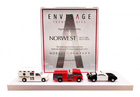 A custom financial tombstone crafted for an equity investment deal in a technology company. This unique deal toy includes three model emergency response vehicles.