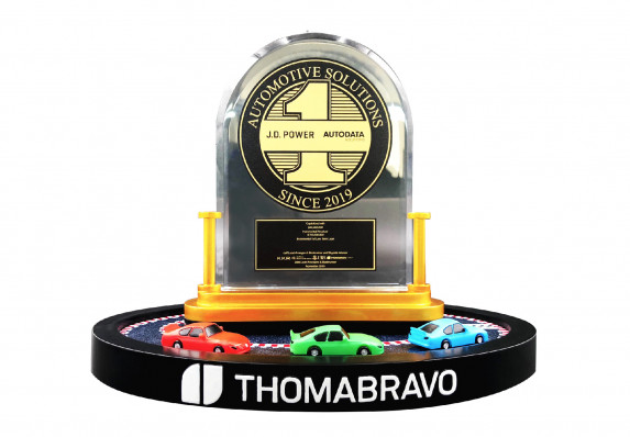 A custom, luxury financial tombstone with a crystal plaque, gold medallion and model cars.