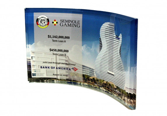 A bevel-edged curved crystal panel with reverse color printing is the canvas for the details of this large gaming industry financial transaction.