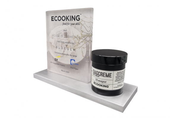 Deal toy presented for a financial acquisition. Reverse printed plaque with color printed logos is presented on a metal base with a cream packaging model