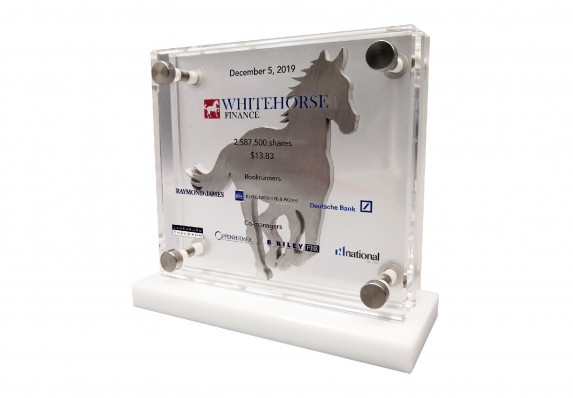 A custom deal toy with financial transaction details presented on a crystal plaque. This unique tombstone includes an elegant brushed aluminum stallion silhouette.