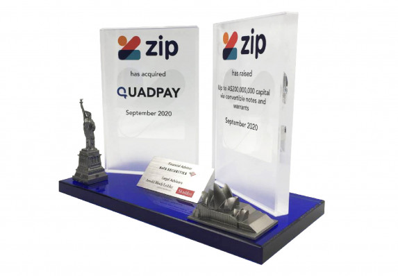 Acquisition deal toy with double color printed plaques and cast metal models of the Statue of Liberty and the Sydney Opera House.