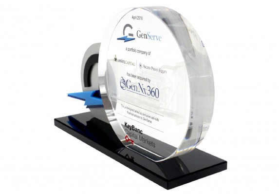 Round crystal plaque with tombstone text and etching detail mounted on base alongside custom machined logo.