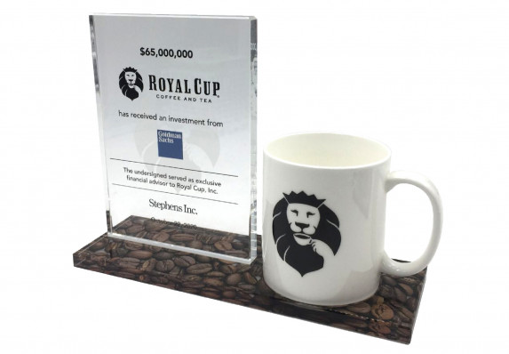 A crystal tombstone plaque mounted on a color printed base with a logo coffee mug presented for an investment deal.
