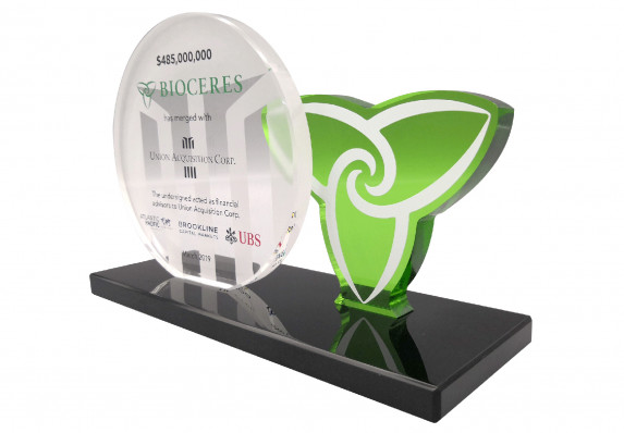Two custom-cut plaques are presented on a sleek black base in this logo-centric custom deal toy for a financial merger.