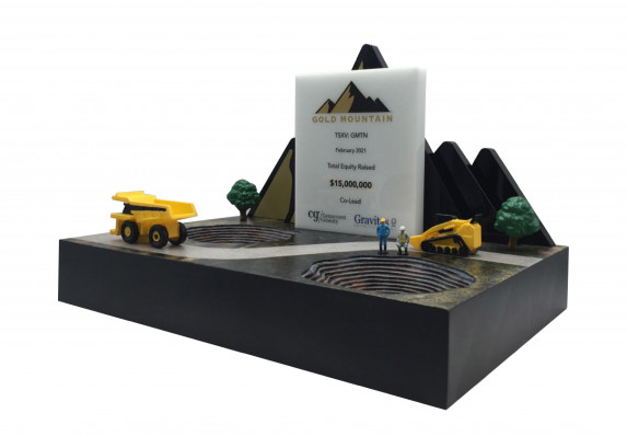 This complex deal gift combines 3D printed construction vehicles with plaque printed with financial transaction details.