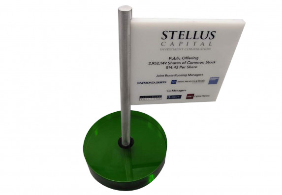 A luxury deal toy crafted to look like a gold flag that contains the logos and specifics of an initial public offering.