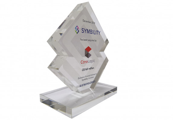 This logo silhouette plaque is mounted on a matching base and printed in color with the transaction details for an M&A deal.