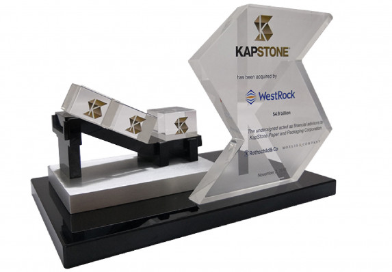 Model conveyor belt with logo etched boxes mounted on base with transaction tombstone for an acquisition deal.