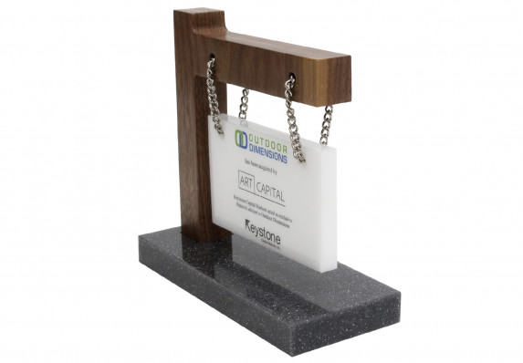 Tombstone crafted by Society Awards Finance Group for an M&A deal. The design incorporates a hanging plaque attached to a wood arm and base with chain.