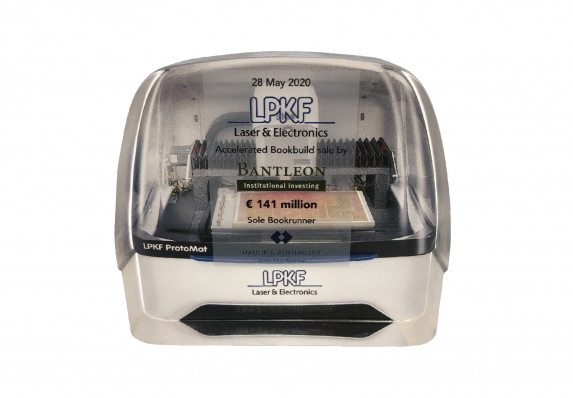 Model deal gift presented for a laser and electronics brand financial transaction.