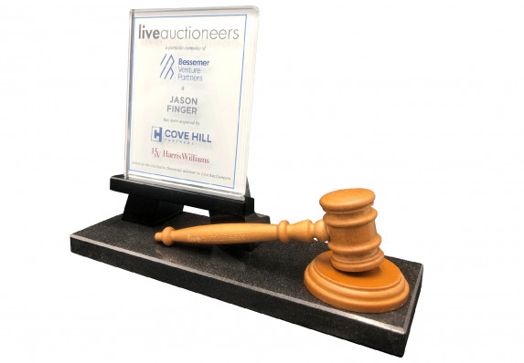 This custom deal gift combines an auctioneer's gavel and a crystal tombstone plaque on a black base to commemorate the sale of a portfolio company.