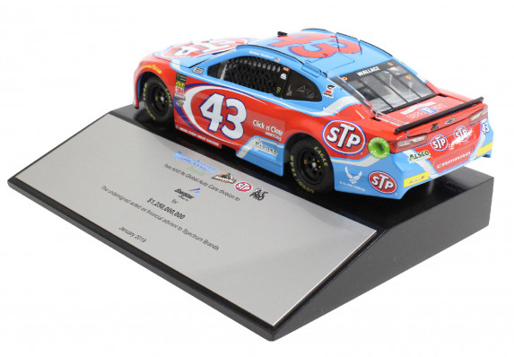 Custom deal gift with a large metal tombstone and brightly colored racecar model mounted on top. This luxury high-end tombstone commemorates the sale of an auto care division.