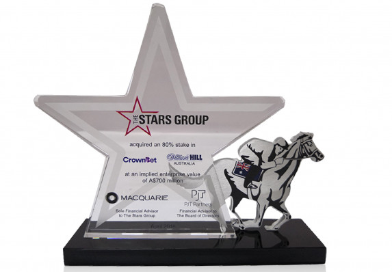 A custom star plaque with transaction details is mounted alongside a race horse with jockey in this stake acquisition deal gift.