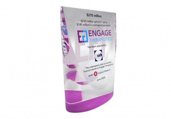 Colorful custom crystal deal toy with high-quality color-printed logos and tombstone text presented for the acquisition of a therapeutics brand.